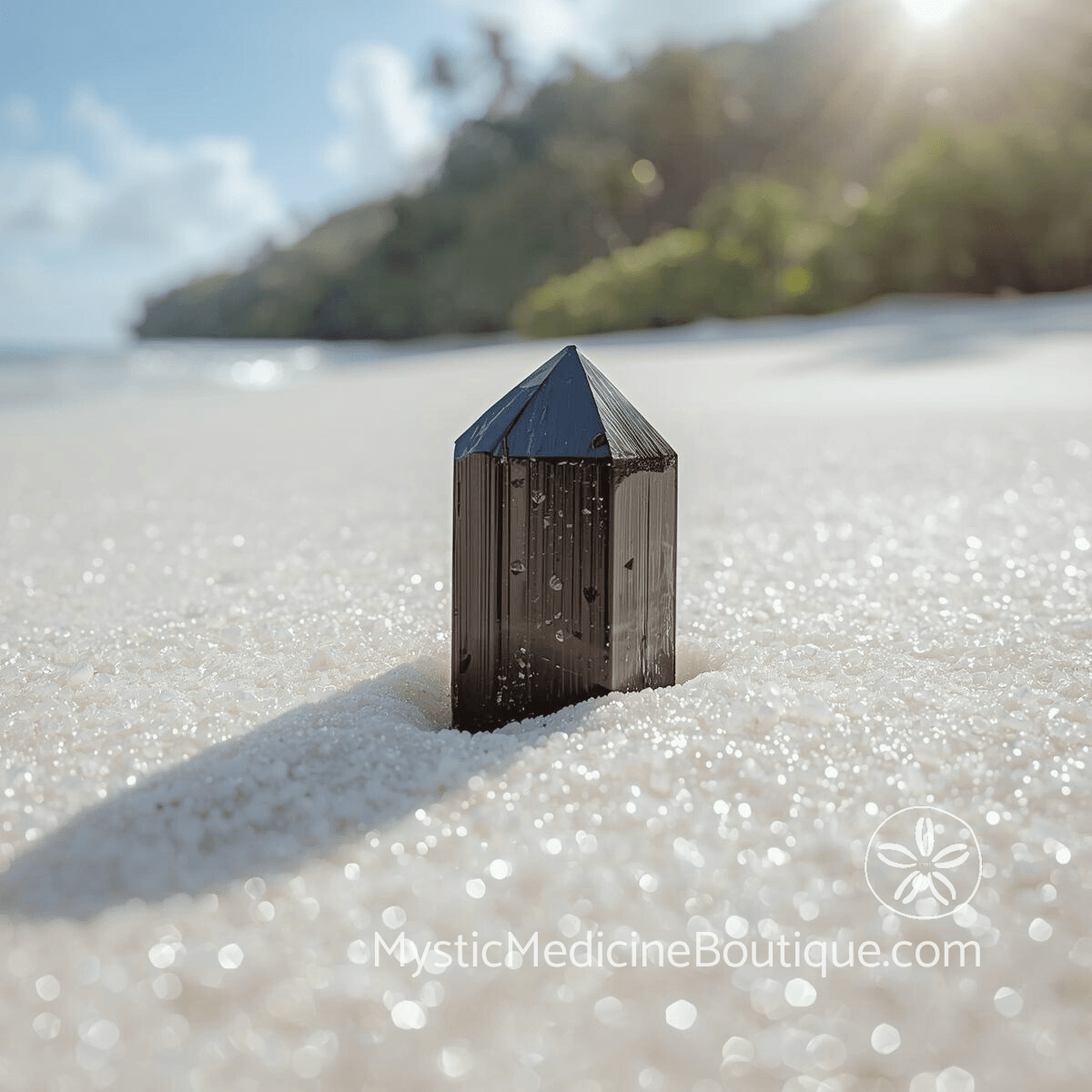 Black tourmaline crystal point standing in white sand on a tropical beach representing the grounding and protective properties of this powerful stone