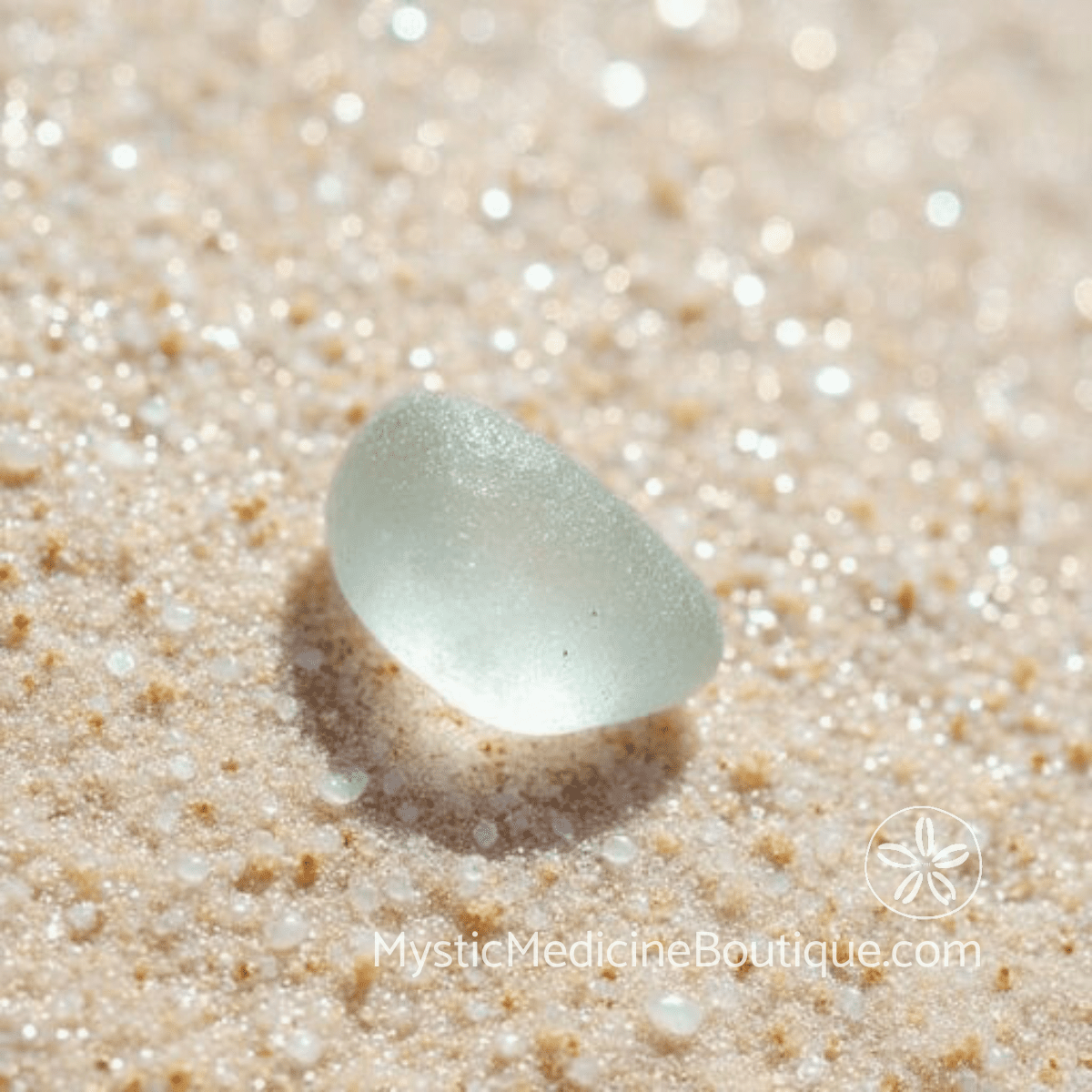 Pale green sea glass on tropical sand representing psychic protection for empaths and highly sensitive people
