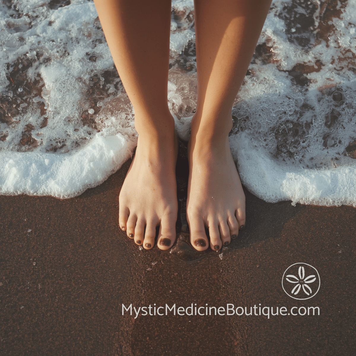 Bare feet standing on wet dark sand with ocean foam washing over toes at water's edge — how to ground yourself during kundalini awakening