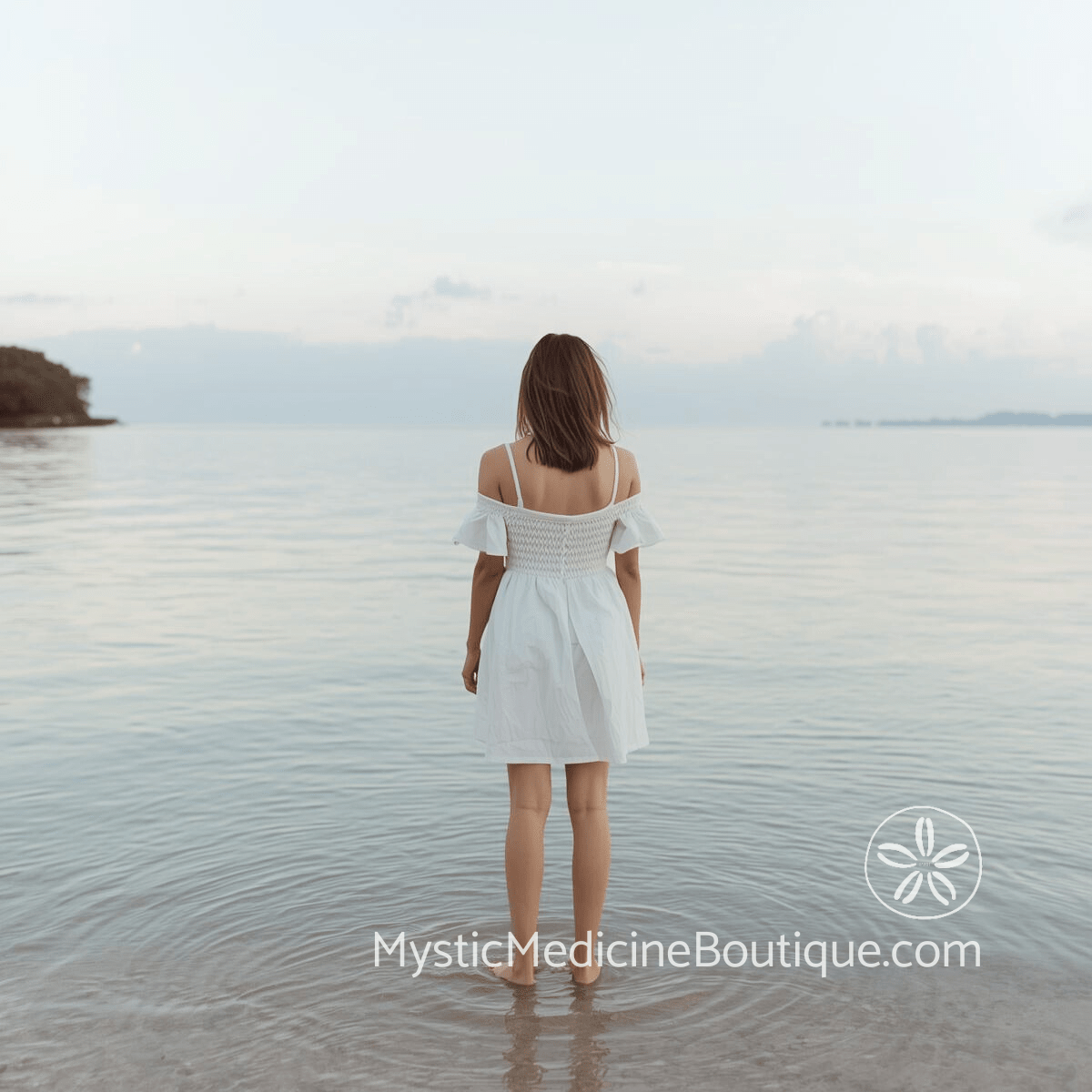 Woman in white dress standing still at the edge of calm tropical water at dawn with soft overcast sky, representing the pause and honest reassessment of whether spiritual awakening is supposed to feel this difficult