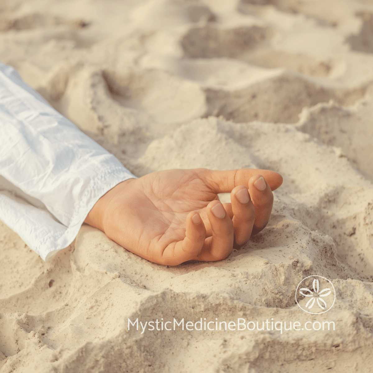 Hand resting in gentle mudra on soft beach sand wearing white — kundalini practices making you feel worse when to pause safely