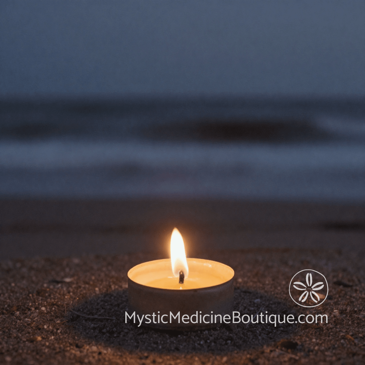 Small candle flame burning on dark coastal beach representing spiritual burnout meaning as depletion not spiritual failure — Mystic Medicine Boutique