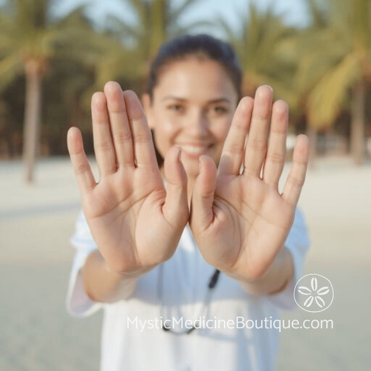 Woman with open raised palms smiling outdoors representing authentic expression restored through integrated nursing and Reiki Master throat chakra expertise