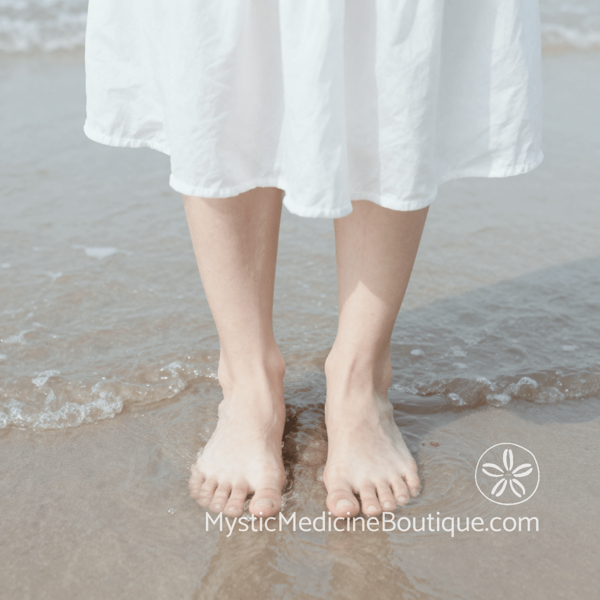 Bare feet in white dress standing at tropical shoreline representing why spiritual burnout feels so physically exhausting in body and nervous system — Mystic Medicine Boutique